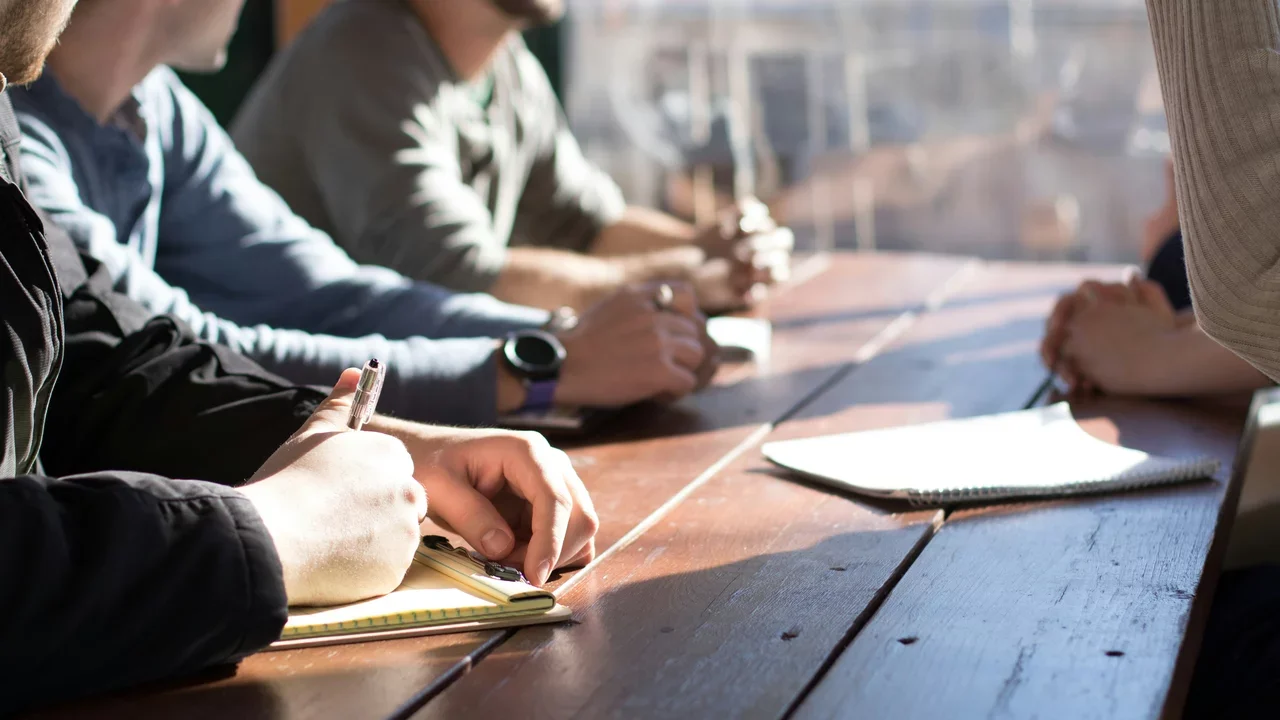 Three people seated at a table reviewing documents